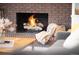Cozy brick fireplace with a lit fire, complemented by a plush throw and inviting decor at 5557 E Links Cir, Centennial, CO 80122