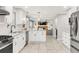 Updated kitchen with stainless steel appliances, white cabinetry, tiled backsplash, and access to living spaces at 5557 E Links Cir, Centennial, CO 80122