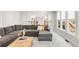 Open-concept living room showcasing a gray sectional couch and an open view into the kitchen at 5557 E Links Cir, Centennial, CO 80122