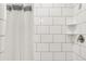 Tiled shower with a clear glass door, shelving, and modern fixtures at 5557 E Links Cir, Centennial, CO 80122