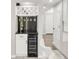 Custom wet bar with a wine refrigerator, dark granite countertops, and display shelving for bottles and glasses at 5557 E Links Cir, Centennial, CO 80122