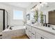 Modern bathroom with dual sinks, quartz countertops, and luxurious soaking tub with shower at 42979 Colonial Trl, Elizabeth, CO 80107