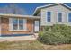 Home's front exterior with brick accents, front shrubs and covered entry at 907 Stein St, Lafayette, CO 80026
