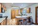 Cozy kitchen featuring wood floors, light wood cabinets, stainless steel appliances, and a kitchen island with barstool seating at 907 Stein St, Lafayette, CO 80026