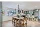 Open concept dining area with a modern chandelier, wood table and seating, and kitchen view at 11870 Tabor Dr, Lakewood, CO 80215