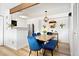 Cozy dining area with wood table, blue chairs, and modern light fixture next to a white kitchen at 209 Wright St # 204, Lakewood, CO 80228