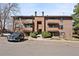 Exterior view of a well-maintained condo building with balconies, reserved parking, and mature trees at 209 Wright St # 204, Lakewood, CO 80228