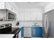 Modern kitchen with stainless steel appliances, blue lower cabinets, and ample countertop space at 209 Wright St # 204, Lakewood, CO 80228
