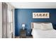 Elegant bedroom featuring a dark blue accent wall and plush bedding, designed for a serene and restful sleep environment at 209 Wright St # 204, Lakewood, CO 80228