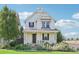 Charming two-story house with white siding, landscaping, and a front porch at 7902 E 49Th Pl, Denver, CO 80238