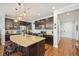 Gourmet kitchen with granite island, stainless steel appliances, and dark wood cabinets at 7902 E 49Th Pl, Denver, CO 80238