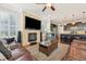 Open living room with a stone fireplace, hardwood floors, and a view into the kitchen at 7902 E 49Th Pl, Denver, CO 80238