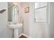 Convenient powder room with pedestal sink and a window for natural light at 7902 E 49Th Pl, Denver, CO 80238