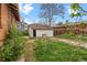 Backyard with detached garage and overgrown weeds at 2701 W Mississippi Ave, Denver, CO 80219