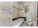 Dated bathroom featuring a bathtub, tiled walls, toilet, and built in cabinet at 2701 W Mississippi Ave, Denver, CO 80219