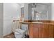 Bathroom with wood vanity, mirror, and toilet, needing renovation at 2701 W Mississippi Ave, Denver, CO 80219