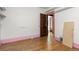 Bedroom with hardwood floors, pink trim, a large closet, and doorway to another room at 2701 W Mississippi Ave, Denver, CO 80219