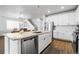 Open-concept kitchen featuring granite countertops, white cabinets, stainless steel appliances and an island with a sink at 18189 House Finch Ln, Parker, CO 80134