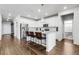 Bright open kitchen features white cabinetry, stainless steel appliances, an island with seating and modern pendant lights at 18189 House Finch Ln, Parker, CO 80134