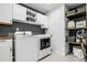 Well-organized laundry room with modern washer/dryer, open shelves, and plenty of storage at 18189 House Finch Ln, Parker, CO 80134