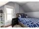 Bedroom with a large window, sloped ceilings and stylish blue bedding create a cozy and inviting space at 2358 N Ogden St # B, Denver, CO 80205