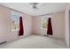 Bright bedroom features neutral carpet, ceiling fan and double windows with privacy curtains at 930 S Dayton St, Denver, CO 80247