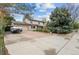 Charming two-story home with an attached garage and spacious driveway bordered by mature trees and landscaping at 930 S Dayton St, Denver, CO 80247