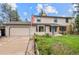 Charming two-story home featuring an attached garage and a well-maintained front yard with an American flag at 930 S Dayton St, Denver, CO 80247