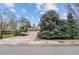 Charming two-story home with an attached garage and spacious driveway surrounded by mature trees and landscaping at 930 S Dayton St, Denver, CO 80247