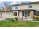 Charming two-story home featuring an attached garage, well-kept lawn, and landscaped garden beds at the front entrance at 930 S Dayton St, Denver, CO 80247
