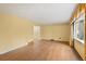 Spacious living room with hardwood floors, large window, and seamless flow to adjacent rooms at 930 S Dayton St, Denver, CO 80247