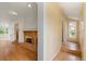Open-concept living space with hardwood floors, brick fireplace, and seamless flow into the adjacent entryway at 930 S Dayton St, Denver, CO 80247