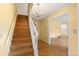Elegant staircase with hardwood steps, white railing, and a decorative chandelier illuminating the entryway at 930 S Dayton St, Denver, CO 80247