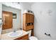 Clean bathroom with wood cabinet and large mirror at 580 Mount Massive St, Berthoud, CO 80513