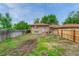 A spacious backyard includes a wood fence, well-maintained lawn, and a brick home in the background at 3854 Perry St, Denver, CO 80212