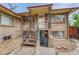 Brick home exterior with metal stairs leading to the front door and lower level entrance at 3854 Perry St, Denver, CO 80212