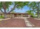 Charming brick duplex with mature trees, rock landscaping, and a walkway leading to the front entrance at 3854 Perry St, Denver, CO 80212