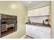 Practical kitchen featuring built-in oven, cooktop and ample cabinet storage at 3854 Perry St, Denver, CO 80212