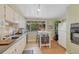 Efficient kitchen with white cabinets, lots of light, and a breakfast nook at 3854 Perry St, Denver, CO 80212