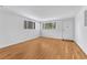 Bright living room with hardwood floors, white walls, and two bright windows at 3854 Perry St, Denver, CO 80212