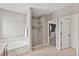 Bathroom featuring a soaking tub, glass-enclosed shower, and access to a walk-in closet at 1822 Painter Dr, Monument, CO 80132