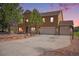 Charming two-story home with a three-car garage, basketball hoop, stone accents, and professionally landscaped front yard at 1822 Painter Dr, Monument, CO 80132