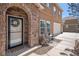 Close-up of the entrance with a decorative wreath, stone archway, and outdoor seating area at 1822 Painter Dr, Monument, CO 80132