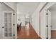Long hallway with hardwood floors and white walls connecting various rooms of the home at 1822 Painter Dr, Monument, CO 80132