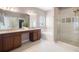 Luxurious main bathroom with dual vanity, soaking tub, glass enclosed shower, and white tiled floors at 1822 Painter Dr, Monument, CO 80132