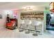 Elegant bar area featuring ample shelving for liquor, a jukebox, and stylish white bar stools at 5553 S Chester Ct, Greenwood Village, CO 80111