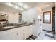 Bathroom with a double sink vanity, large mirror, and tiled floors at 440 Scrub Oak Cir, Monument, CO 80132