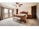 Spacious bedroom featuring a decorative wooden bed frame with a bench and balcony access at 440 Scrub Oak Cir, Monument, CO 80132