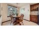 Bright dining area with a round wooden table, chairs, and view of the outdoors at 5046 S Evanston St, Aurora, CO 80015