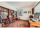 Home office features a wall of bookshelves, a large window and a desk with a monitor and keyboard at 5046 S Evanston St, Aurora, CO 80015